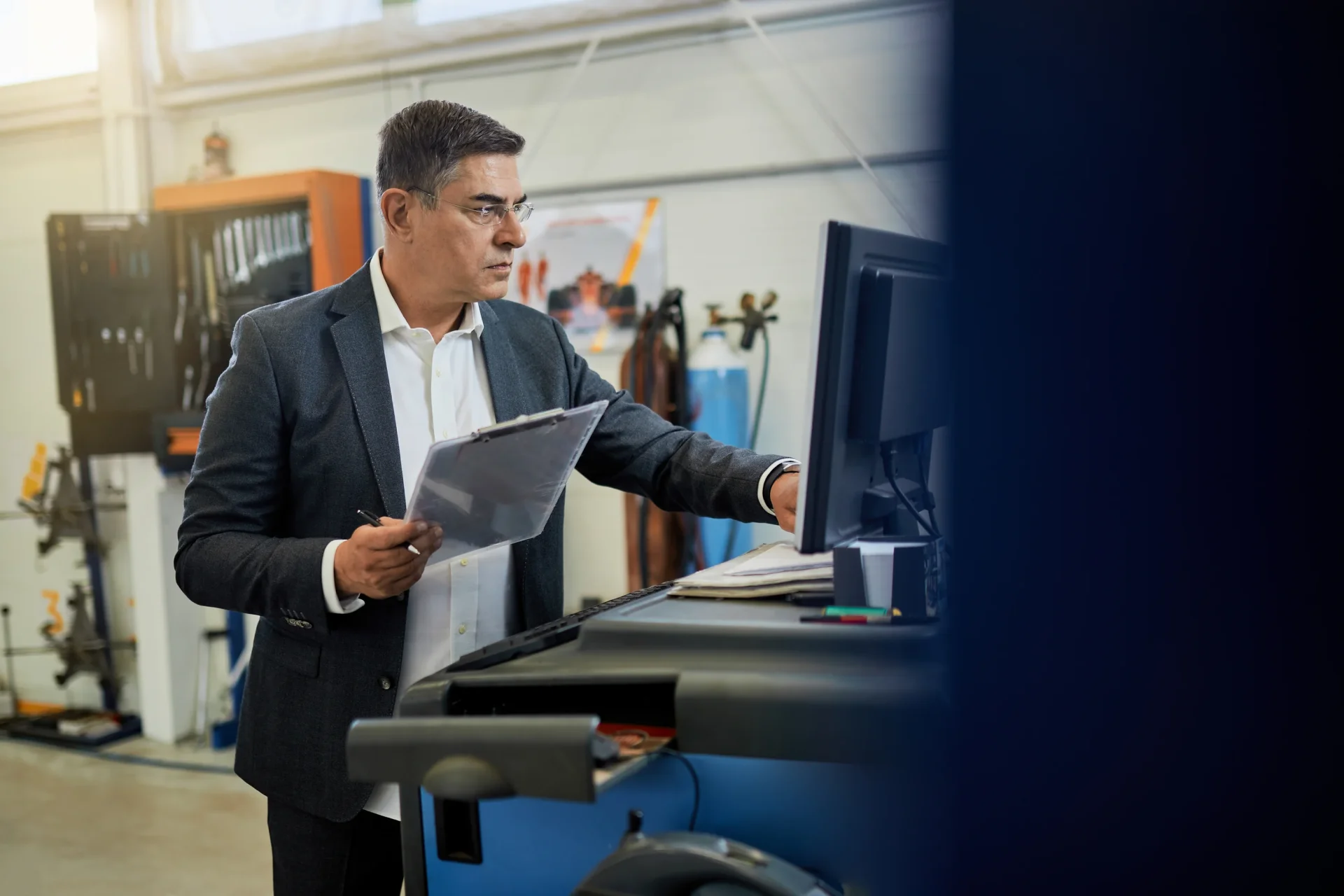 mid-adult-inspector-analyzing-data-while-using-computer-auto-repair-shop mid-adult-inspector-analyzing-data-while-using-computer-auto-repair-shop