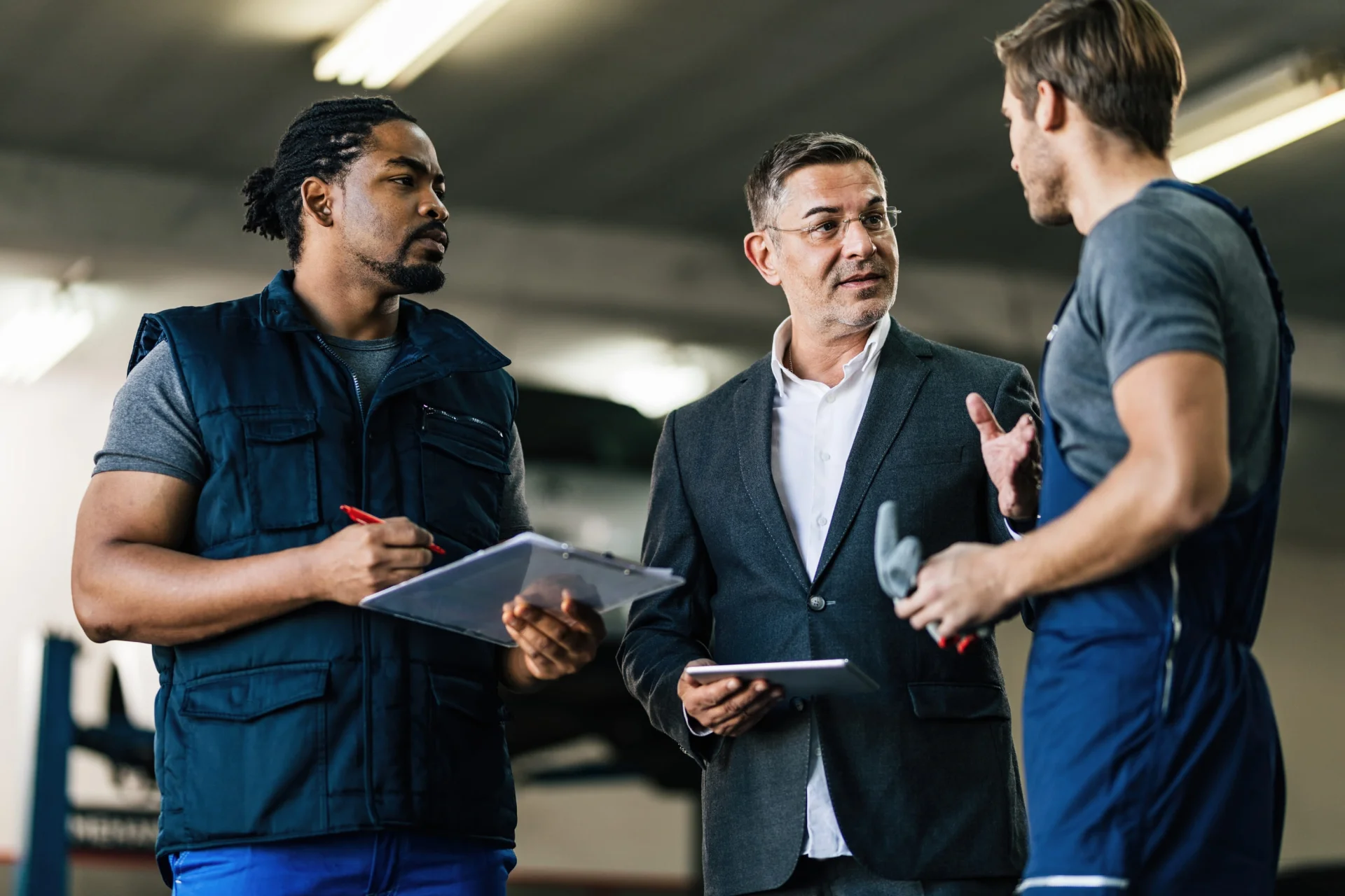 mid-adult-manager-talking-car-mechanics-auto-repair-shop mid-adult-manager-talking-car-mechanics-auto-repair-shop
